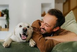 a man lying down with a dog